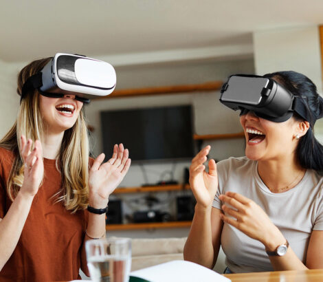 Women wearing virtual reality goggles and a headset, demonstrate the latest in fun technology and virtual innovation.