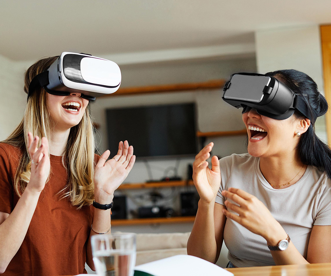 Women wearing virtual reality goggles and a headset, demonstrate the latest in fun technology and virtual innovation.